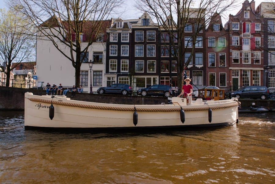 sloep apsara in amsterdamse grachten met schipper