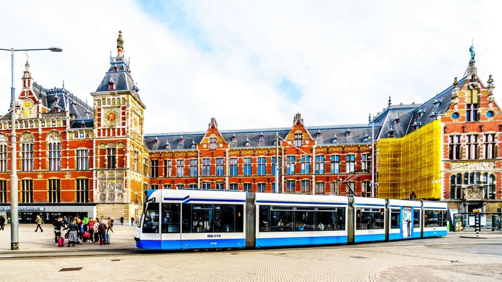 Vooraanzicht Amsterdam Centraal met tram