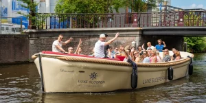 Menschen winken auf einer Luxusschaluppe in Haarlem