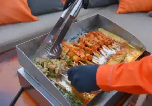 Chef grilt spiesjes op BBQ boot Amsterdam