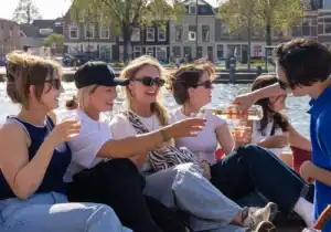 Schipper die wijn inschenkt voor vrouw op borrelboot haarlem