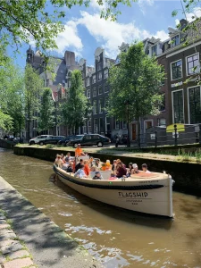 Green marine sloep varend met groep op gracht