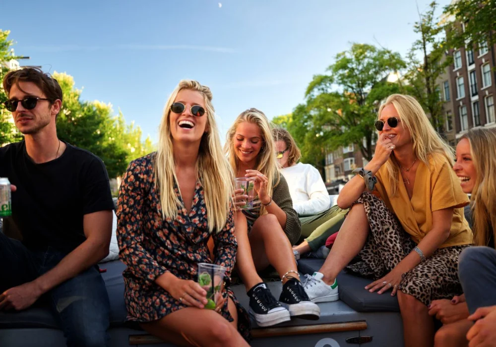 Groep lachende mensen met cocktail in hand