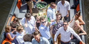 Mann hält ein Bier auf einem Boot