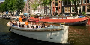 Ein offenes Boot mit Menschen in Amsterdam