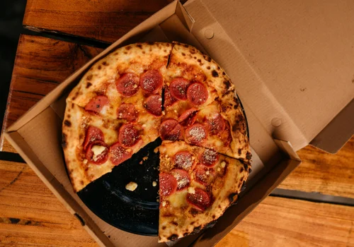 Pizza in einer Schachtel auf dem Tisch