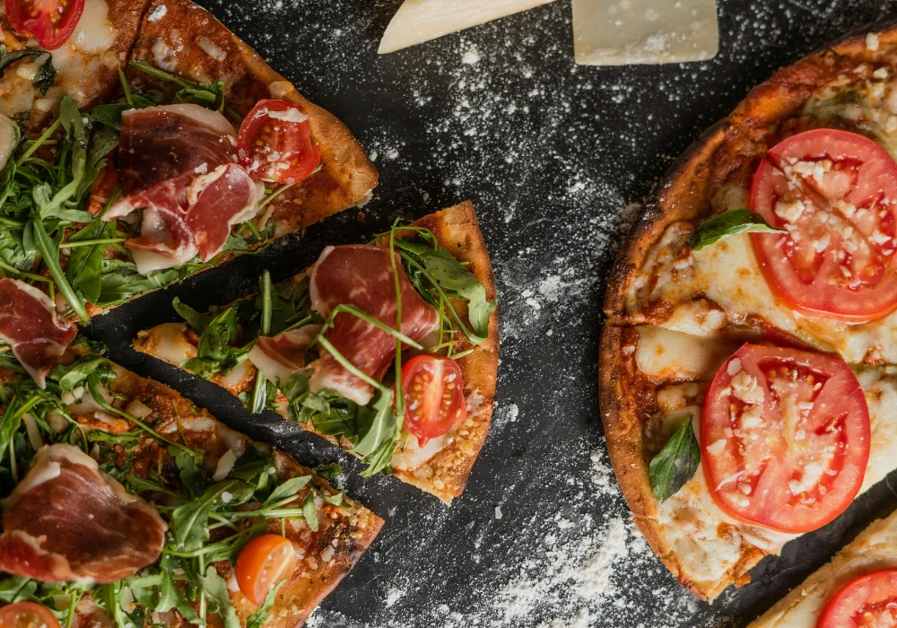 2 Pizzen auf einem schwarzen Tisch