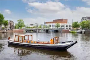 Saloon boat Bartolotti sailing past opera house Amsterdam