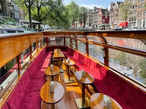 Innenansicht Salonboot Pax – Holztische und Luxusbänke