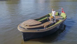 Traditionelles niederländisches Boot auf den Grachten mit Skipper