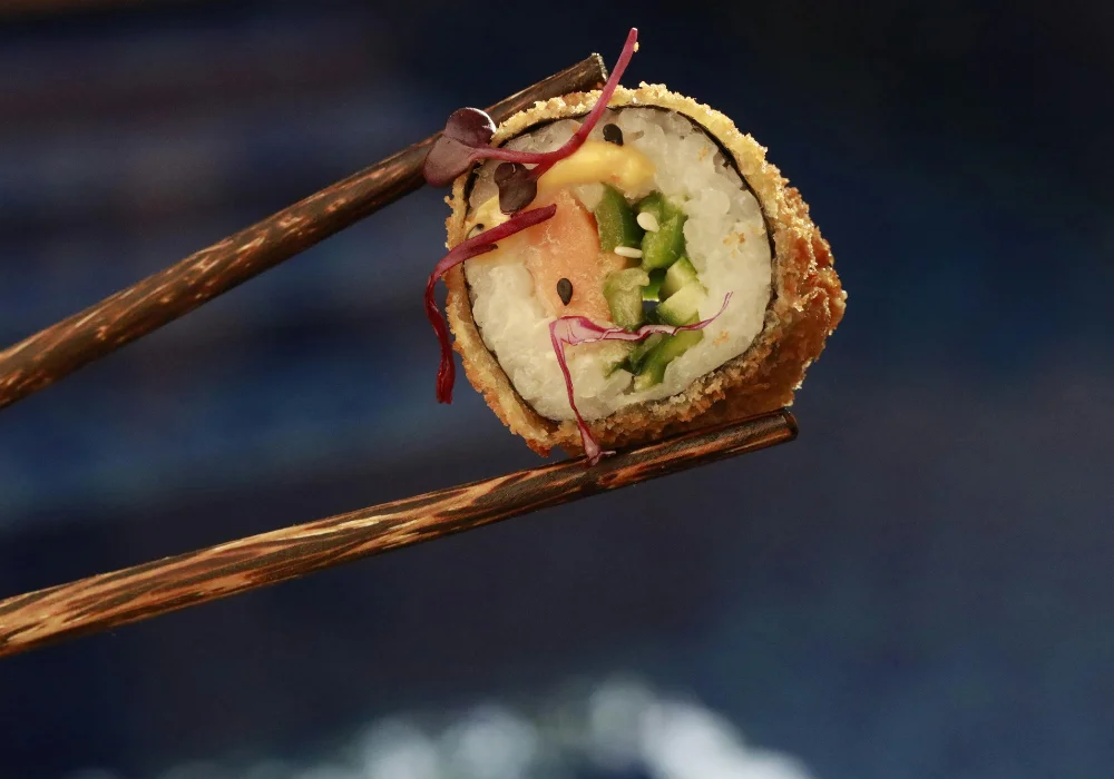 Ein Stück Sushi zwischen Stäbchen
