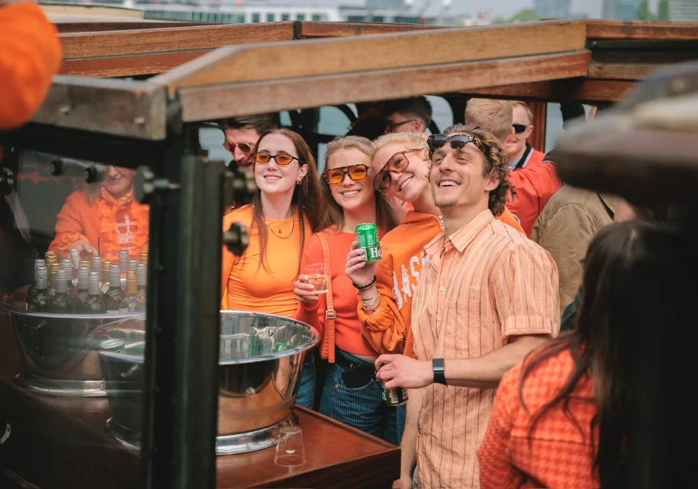 4 mensen die drinken op een koningsdag salonboot