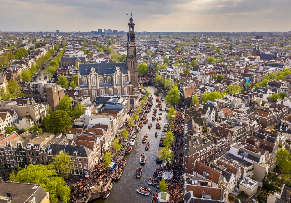 Aerial view of boats in Amsterdam’s canals on King’s Day