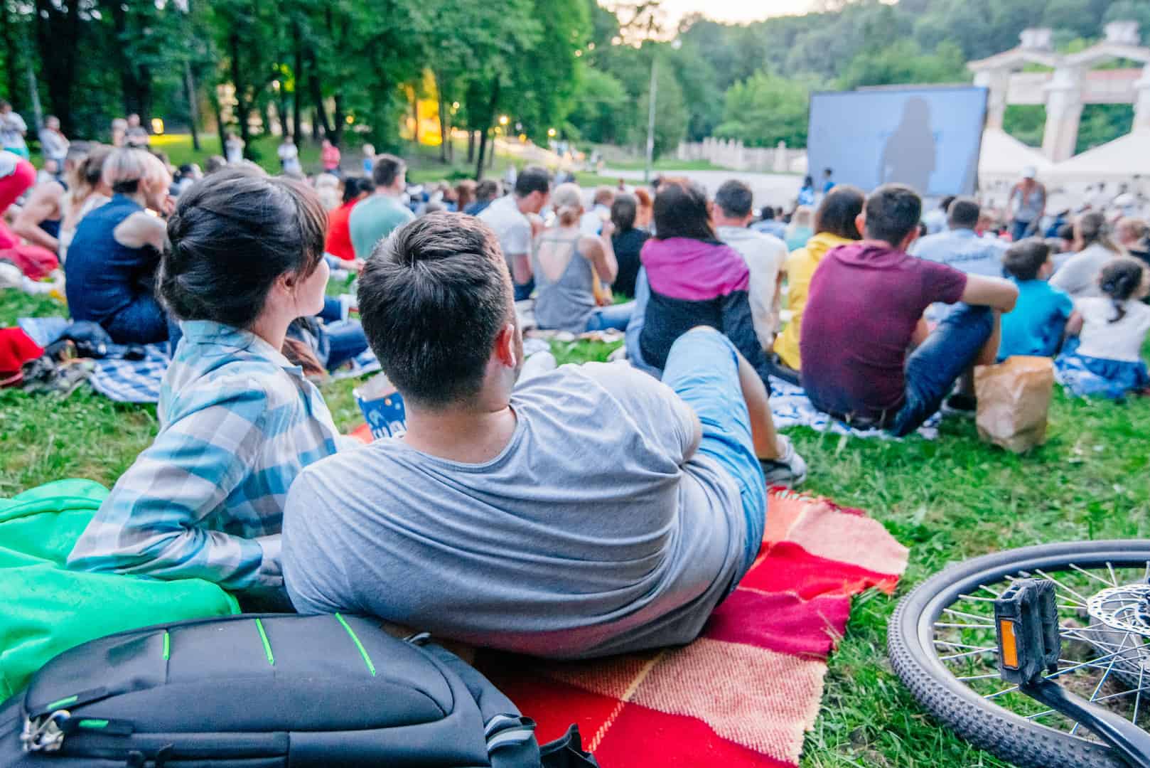 Mensen kijken naar een openluchtbioscoop in een park