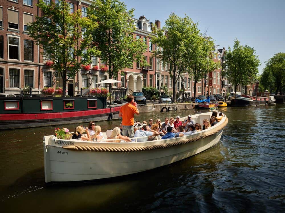 Varen over de Amsterdamse grachten met schipper