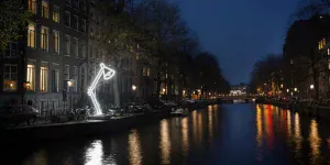 Lichtkunstwerk Two Lamps langs de gracht tijdens het Amsterdam Light Festival