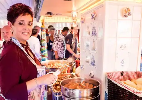 Gastvrouw schept op aan het buffet aan boord van een salonboot